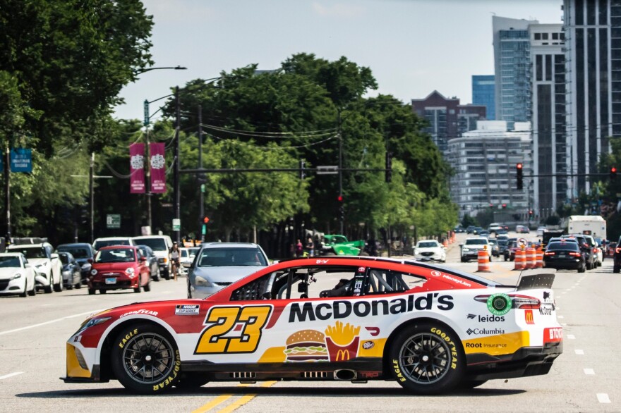 NASCAR driver Bubba Wallace drives a stock car around downtown Chicago in July 2022. During NASCAR’s Street Race weekend in Chicago, many downtown streets will be closed.