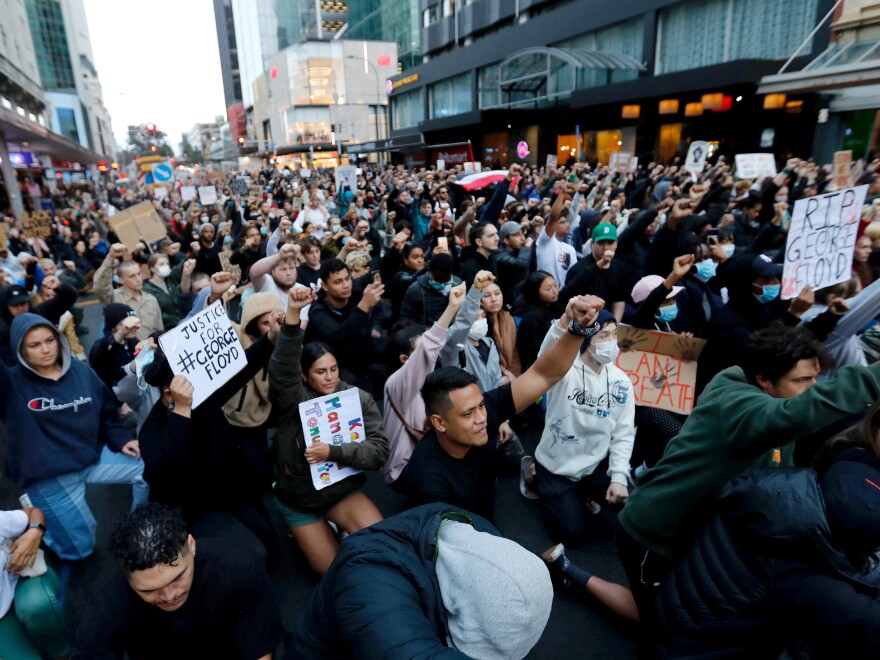 Demonstrators hold placards during a march in central Auckland, New Zealand, on Monday to protest the death of George Floyd.