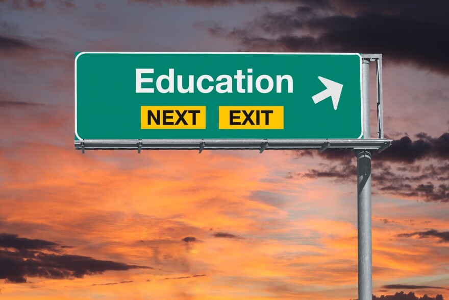 Education next exit freeway sign with sunset sky.