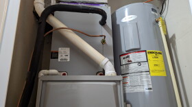 A natural gas furnace and a water heater in a utility closet.