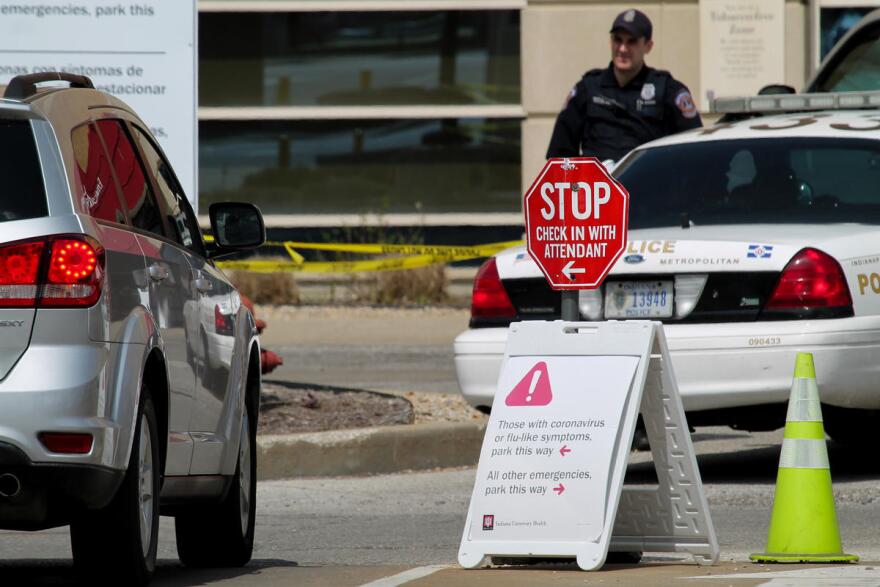 In front of Indiana University Health's Methodist Hospital, signs direct emergency room patients if they are experiencing COVID-19 symptoms.