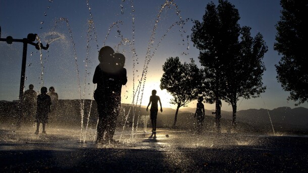 Children play at the Red Ridge Park kids water park, Thursday, June 27, 2013 in Las Vegas. Families stayed past sundown to cool off in the park's fountains after temperatures in Las Vegas hit 112 degrees. A high pressure system parking over the West is expected to bring temperatures this weekend and into next week that are extreme even for a region used to baking during the summer. (AP Photo/Julie Jacobson)