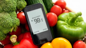 Glucose monitor with fresh vegetables. Healthy food, diet and nutrition.
