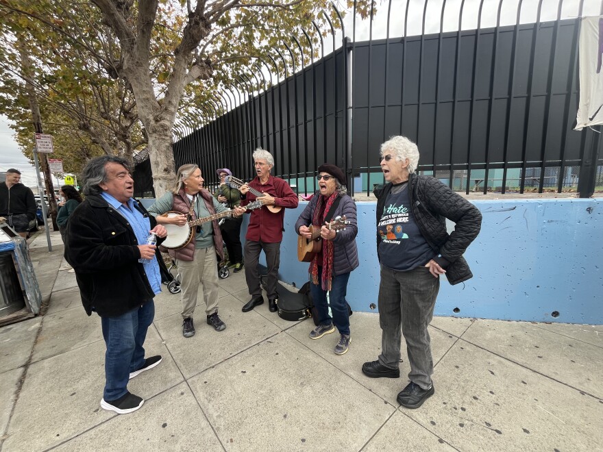A group of musicians performs at a gathering on the corner of Market and Brockhurst in Oakland.