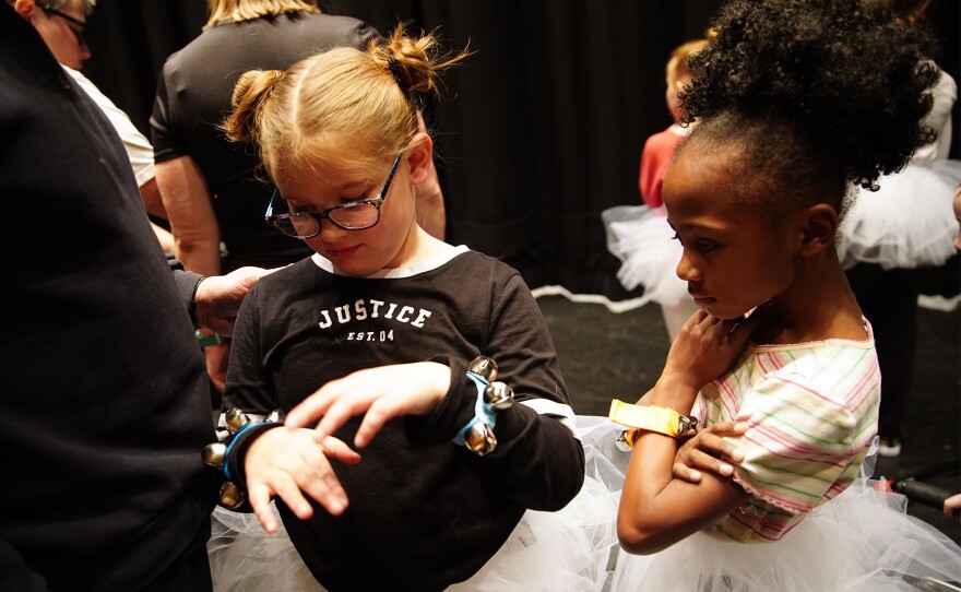 Addison Ebie, 7, (left) and Noel McCann, 7, (right) wait on stage during a rehearsal for Dance Unlimited's upcoming holiday recital.