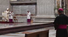 Pope Francis, left, delivers his message during a Mass for Holy Thursday, inside St. Peter's Basilica at the Vatican, Thursday, April 9, 2020. Francis celebrated the Holy Week Mass in St. Peter's Basilica, which was largely empty of faithful because of restrictions aimed at containing the spread of COVID-19. The new coronavirus causes mild or moderate symptoms for most people, but for some, especially older adults and people with existing health problems, it can cause more severe illness or death. (Alessandro Di Meo/Pool Photo via AP)