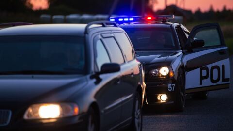 nighttime police traffic stop in with police car with lights on 