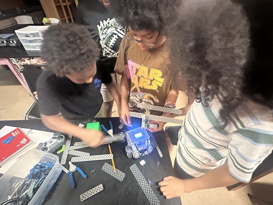 Image, three youth building a simple robot.