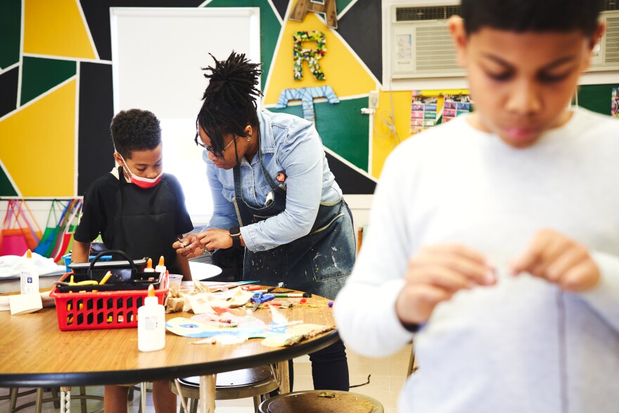Ashley R Thompson (aka Ms. Art) helps students with their projects in her classroom at Howard Hall Elementary in Fayetteville, NC.