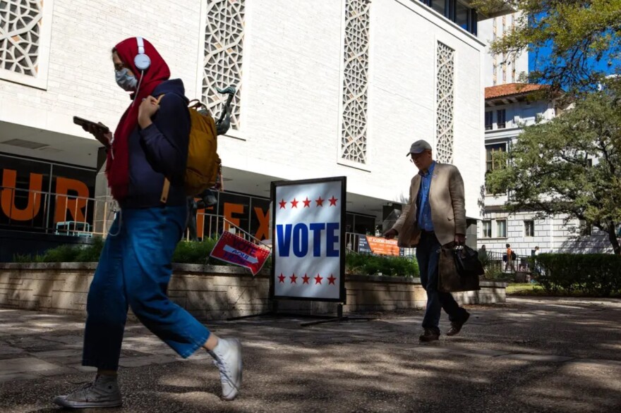 Students and faculty walk past the Peter T. Flawn Academic Center at the University of Texas at Austin while early voting takes place Oct. 25. So far, fewer Texans have voted in 2022 than in 2018, the last midterm election.