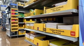 An end cap of an aisle at Walmart holds yellow boxes of notebooks. 