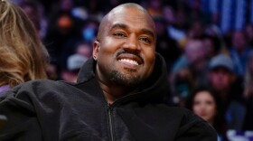 FILE - Kanye West, known as Ye, watches the first half of an NBA basketball game between the Washington Wizards and the Los Angeles Lakers, on March 11, 2022, in Los Angeles. (AP Photo/Ashley Landis, File)
