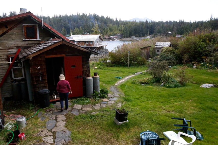 Cassy and the family cat walk across the Peaveys' property in Meyers Chuck, a view of the water in the distance.