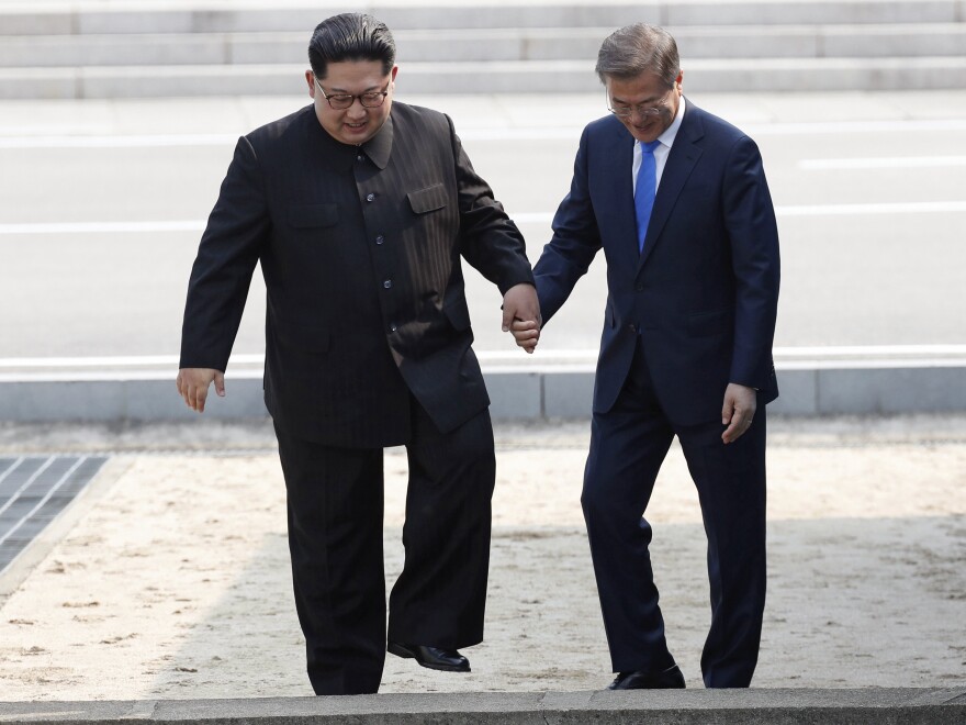 On April 27, North Korean leader Kim Jong Un (left) and South Korean President Moon Jae-in cross the border line in the the Demilitarized Zone between their countries.