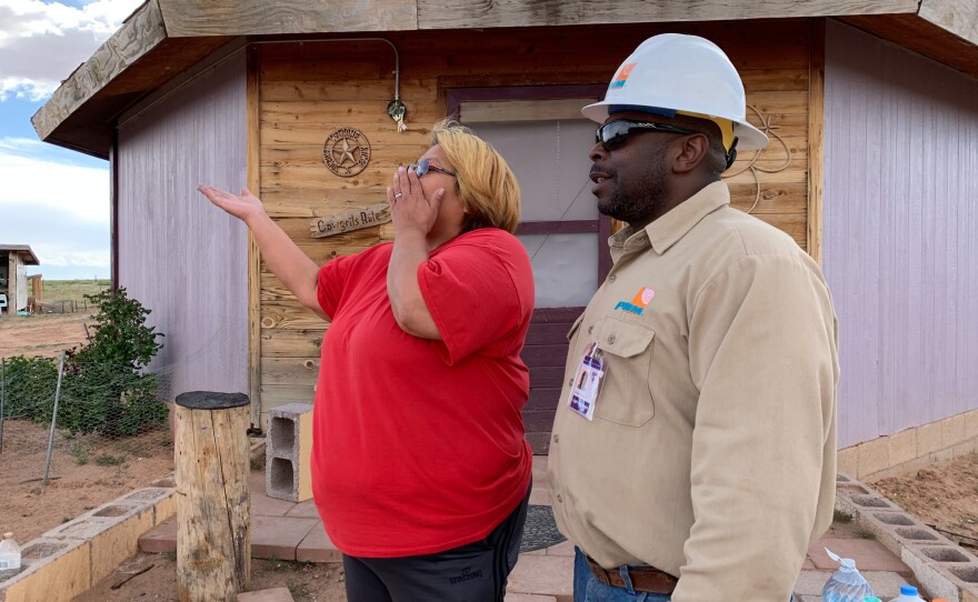 Brian Cooper of PNM Electric in New Mexico tells Neda Billie that the company would like to give her family a refrigerator. Several crews from utilities around the country are volunteering their time to connect people like the Billies to the power grid.