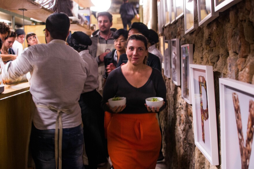 NPR's Lulu Garcia-Navarro volunteers as a server and carries dishes during the dinner.