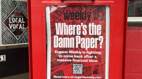 An empty newspaper box that says "Eugene Weekly." 