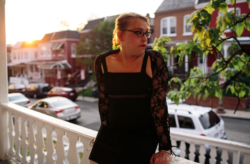 Kiera Atkins smokes on the porch of a transitional group home for transgender adults who are trying to get on their feet.