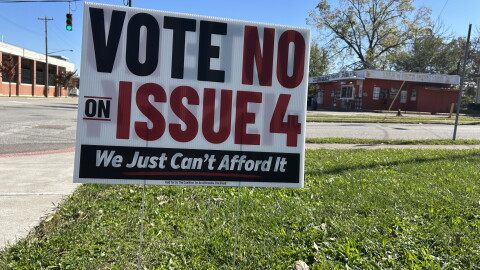 A yard sign on a corner in Evanston reads "Vot No on Issue 4. We just can't afford it."