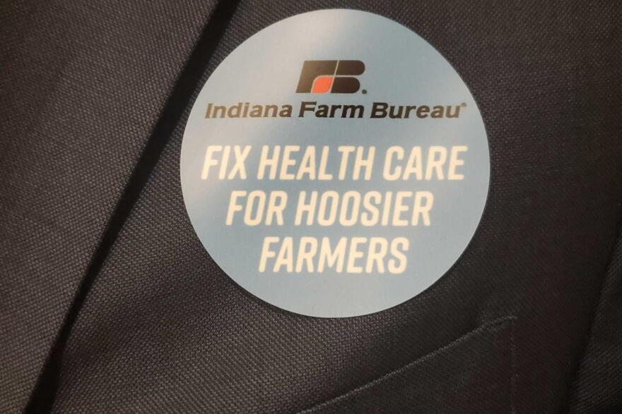 Indiana Farm Bureau members wear stickers to show support for a bill that would allow the organization to offer health benefit plan.
