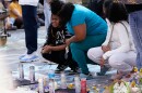 People mourn near a memorial at the site where a man was shot and killed on Wednesday by Madison police, Thursday, July 23, 2026, in Madison, Wisconsin.