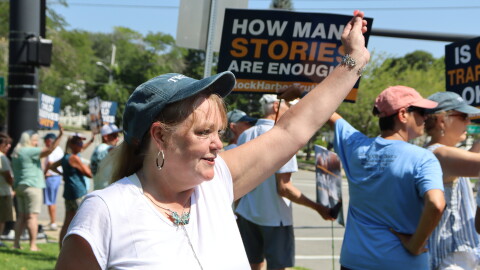 Bonnie Zampino waves to onlookers at a rally in Orleans to support former and current residents of the Community of Jesus. Zampino, who says she lived at the religious commune as a teen, tells CAI and the Provincetown Independent she was sexually abused by the group's doctor.