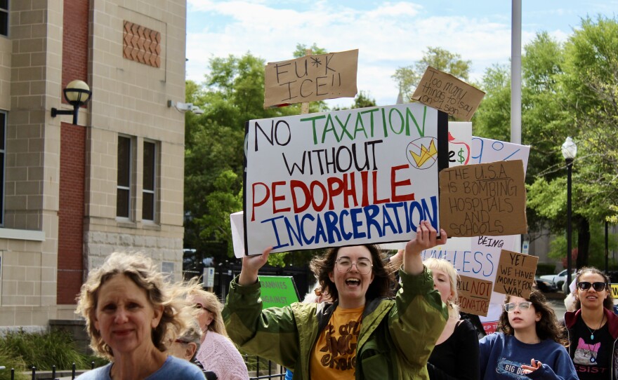 Protestor from the marching holding a sign stating "No taxation without pedophile incarceration" heading towards Princess street.