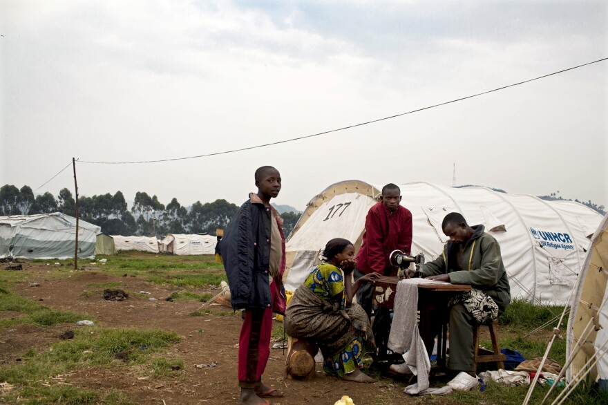 A Congolese man who fled eastern Congo for shelter at a Ugandan refugee camp lugged his sewing machine with him. U.N. officials say tens of thousands have fled for Uganda and Rwanda in recent months.