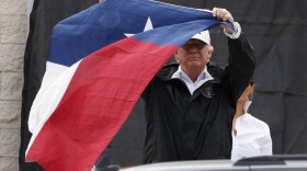 President Donald Trump holds up a Texas flag after speaking with supporters outside Firehouse 5  in Corpus Christi, Texas, Tuesday, Aug. 29, 2017. (Evan Vucci/AP)