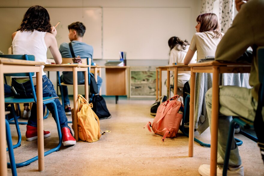 A group of students sitting at desks inside a classroom.