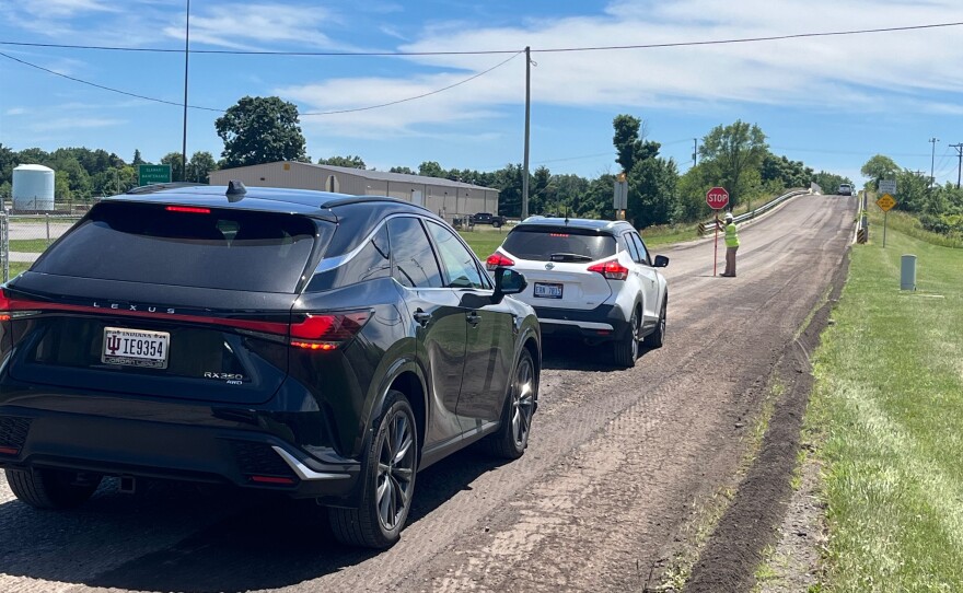 A Milestone Contractors worker stops traffic Monday on southbound Ash Road in St. Joseph County, near its bridge over the Indiana Toll Road in Granger, as a crew removes the road surface in preparation for a new layer.