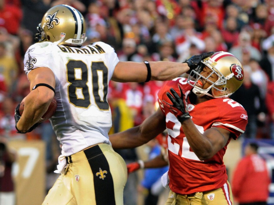 Jimmy Graham of the New Orleans Saints stiff-arms Carlos Rogers of the San Francisco 49ers during a playoff game in San Francisco on Jan. 14. The Saints reportedly gave out bounties to players who attempted to knock out players on opposing teams.
