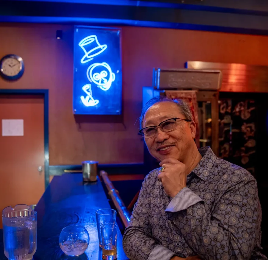 Owner John Chan sits in front of his custom neon art, which helps add to the distinctive ambiance of his revered music and supper club.