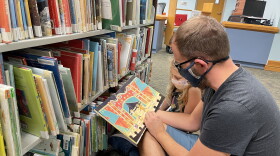 David and Elise Voltmer read a book at Millhopper Branch Library in Gainesville. (Grace Banahan/WUFT News)