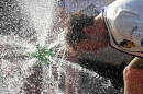  A person cools off with his head in a water spray 