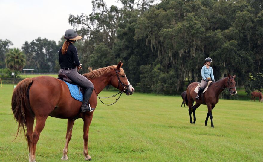 Ashley Johnson, left, coaches her student Anais Naoumoff, while riding Sprout, a 14-year-old chestnut mare on Wednesday, Sept. 27, 2023, at her barn in Ocala, Fla. Johnson has been coaching equestrian professionally since she was in high school. “I learned that I loved helping people and I loved helping the horses,” Johnson said. “I love the process of the development.”