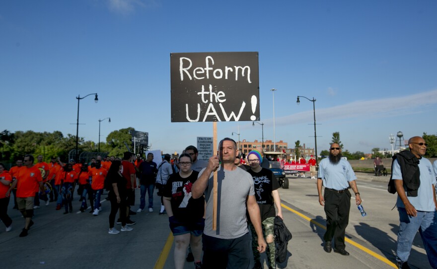 A United Auto Workers member holds a sign reading "Reform the UAW!" during a protest at a Labor Day parade in Detroit.