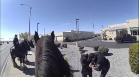 This photo taken from Albuquerque Police Department police video shows police making an arrest on March 20, 2024 after a chase with a horse-mounted police officer in Albuquerque, N.M. The shoplifter was detained outside a Walgreens.