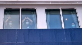 Passengers watch as others are disembarked from the hantavirus-stricken cruise ship MV Hondius at the port of Granadilla in Tenerife, Canary Islands, Spain, Sunday, May 10, 2026.