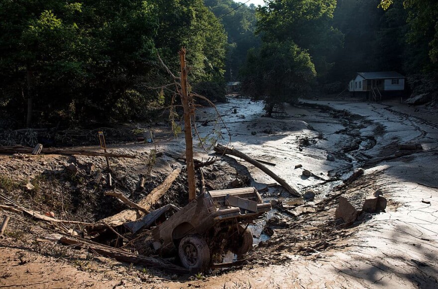 A truck lies in a hole among the mud after it was washed out of the driveway from the flooding on June 25, 2016 in Clendenin, West Virginia. The flooding of the Elk River claimed the lives of 26 people in West Virginia. (Ty Wright/Getty Images)