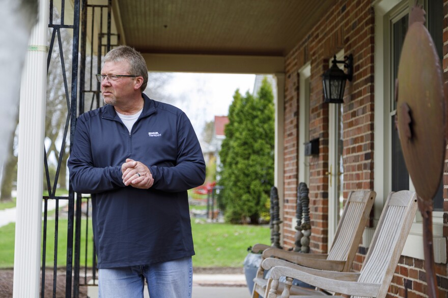 George Cooper, a truck driver for Kohler, stands on the front porch of his home. When he started his job at Kohler two years ago, Cooper realized his pay and benefits were no match to those of other drivers doing the same work.