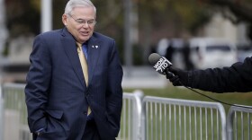 U.S. Sen. Bob Menendez, center, shrugs as a reporter asks him questions while leaving the Martin Luther King Jr. Federal Courthouse after stopping in to appear on his corruption trial, Tuesday, Nov. 14, 2017, in Newark, N.J. Jury deliberations in the bribery trial of Menendez continued Tuesday. (AP Photo/Julio Cortez)