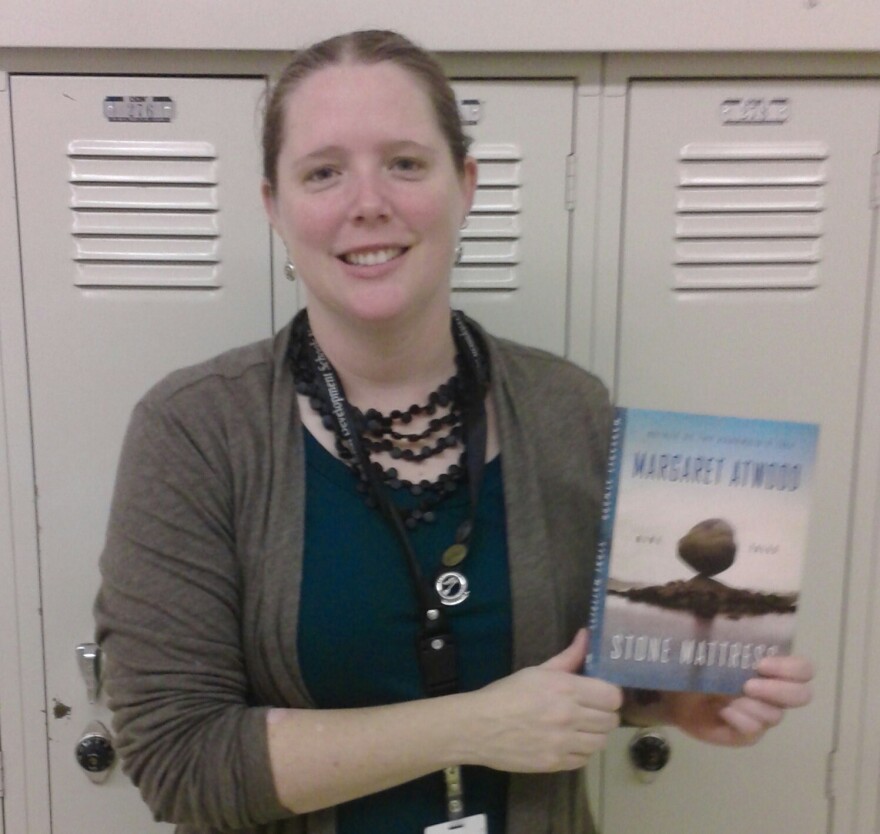 Reviewer Kate Hoffman holding the book "Stone Mattress."