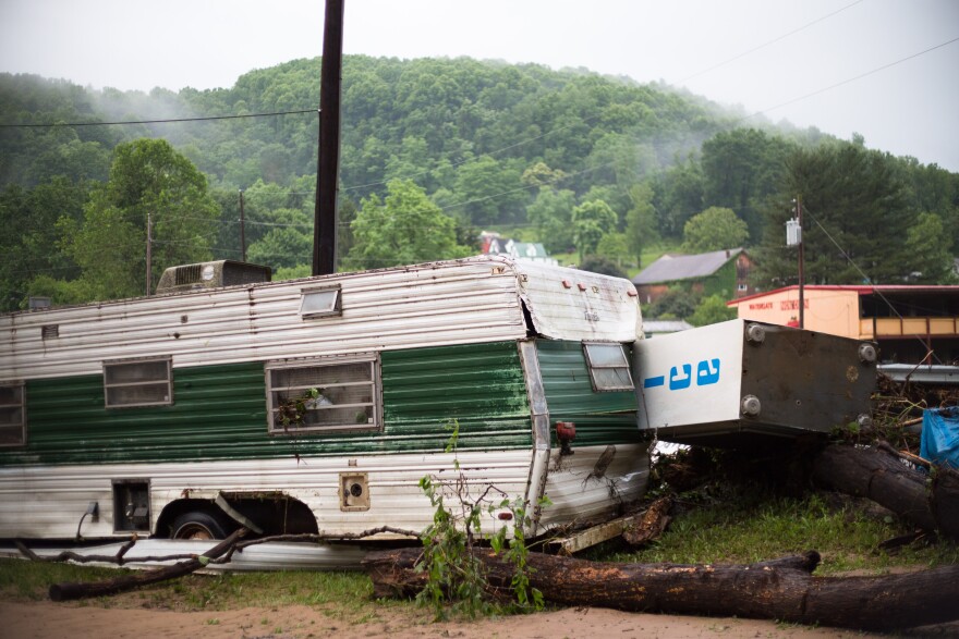 A battered trailer and ice chest sit beside the river in the early Friday morning.