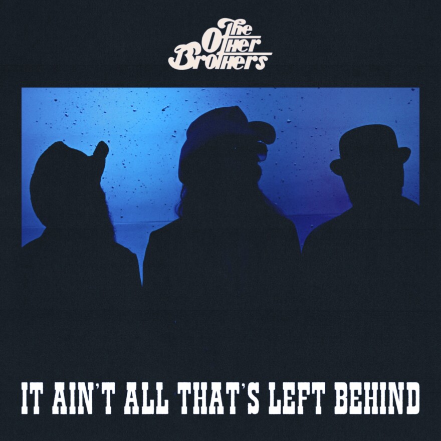 The album cover for the latest album from The Other Brothers. The band of three is silhouetted black against a dark blue album.