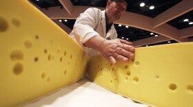Americans are eating more cheese now than ever before: The country consumed around 37 pounds per capita in 2017. But it's not enough to make a dent in the U.S.' 1.4 billion-pound cheese surplus. Pictured: A volunteer opens a round of Swiss cheese during the World Championship Cheese Contest, March 6, 2018, in Madison, Wis. (Carrie Antlfinger/AP)