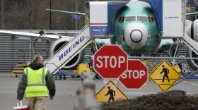 In this Monday, Dec. 16, 2019, file photo, a Boeing worker walks in view of a 737 MAX jet in Renton, Wash. (Elaine Thompson, File/AP)