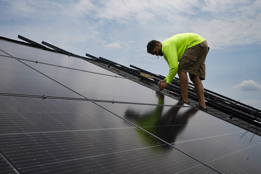 A worker secures a solar panel on the roof of a home in Frankfort, Ky.