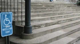 A handicap sign near a large flight of stairs on Murray State's campus. The ramp is around the corner.