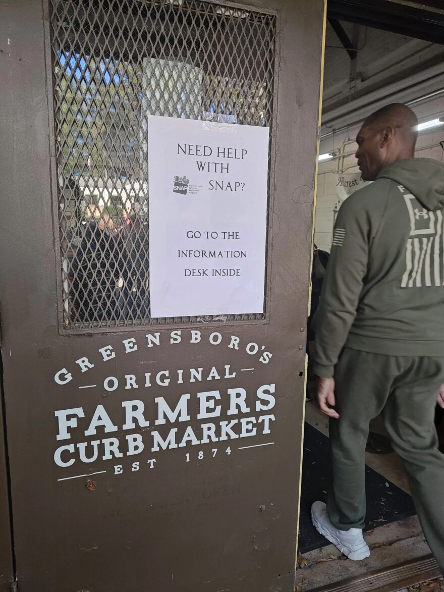 A sign directs SNAP recipients to go to the information desk at the Greensboro Farmers Curb Market on Saturday, Nov. 1, 2025, in Greensboro, N.C.